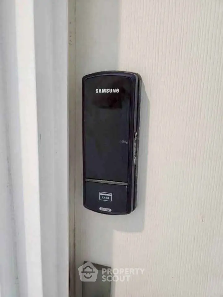 Modern digital door lock on a sleek white door for enhanced security.