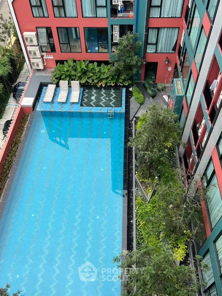 Stunning aerial view of modern apartment complex with inviting swimming pool and lush greenery.