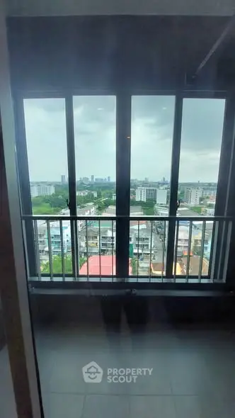 Stunning high-rise apartment view with expansive cityscape and lush greenery, perfect for urban living.