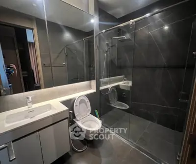 Modern bathroom with sleek design, glass shower, and elegant fixtures.