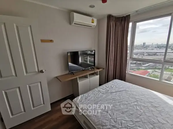 Cozy bedroom with city view, featuring a wall-mounted TV and air conditioning.