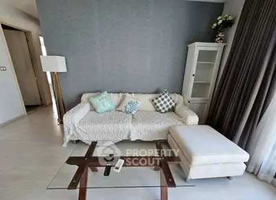 Cozy living room with stylish sofa, glass coffee table, and elegant decor.