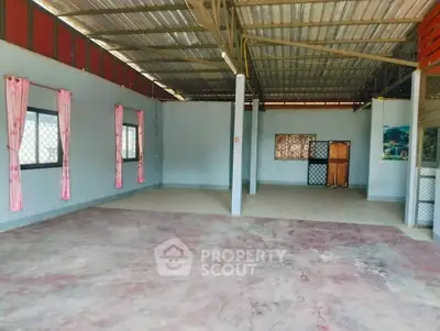 Spacious open-plan interior with potential for customization, featuring large windows and high ceilings.