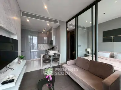 Modern open-plan living room with sleek kitchen and cozy bedroom in luxury apartment.