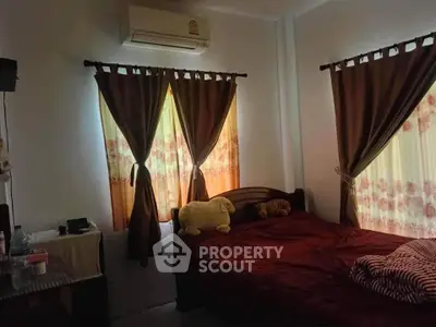 Cozy bedroom with dark curtains and air conditioning unit, perfect for restful nights.