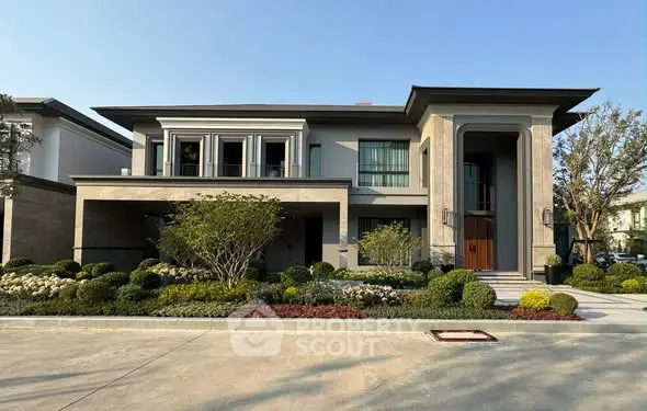 Luxurious modern house with manicured garden and grand entrance