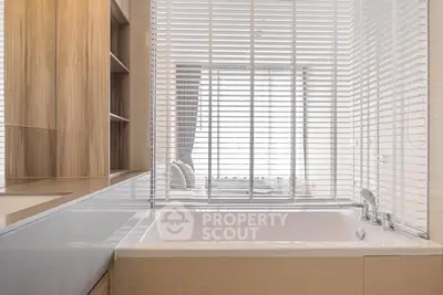 Modern bathroom with sleek bathtub and stylish blinds for privacy