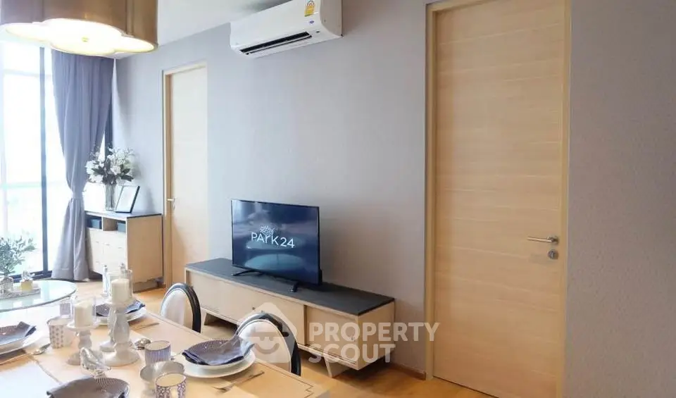 Modern dining area with stylish decor and wall-mounted TV in a contemporary apartment.