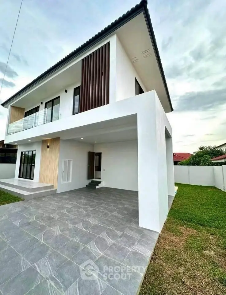 Modern two-story house with sleek design and spacious outdoor area, perfect for family living.