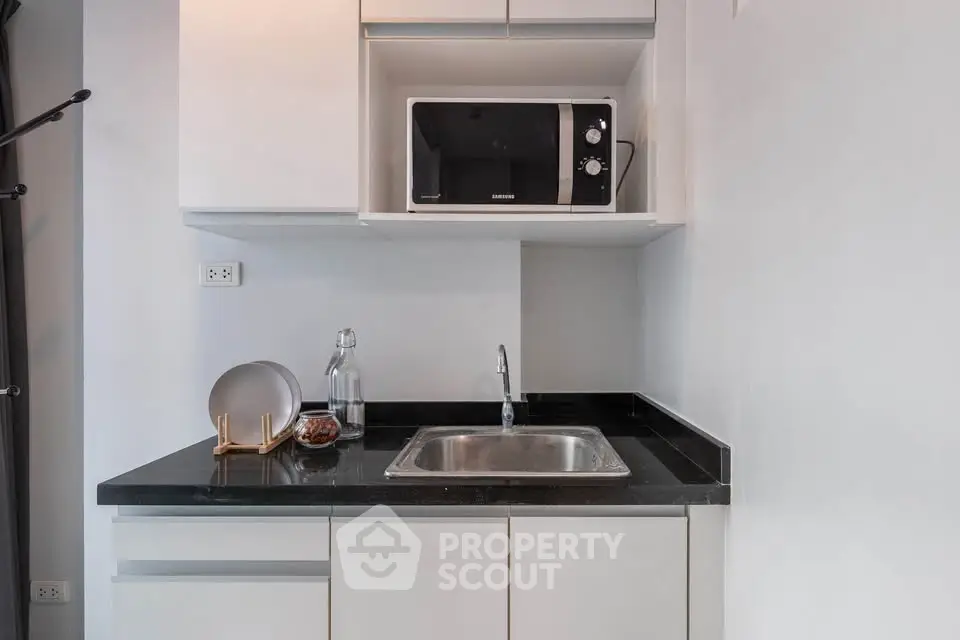 Modern kitchen with sleek black countertop and built-in microwave