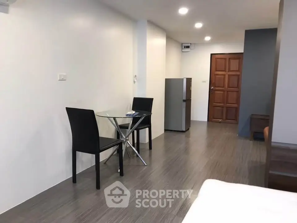 Modern studio apartment with sleek flooring and compact dining area