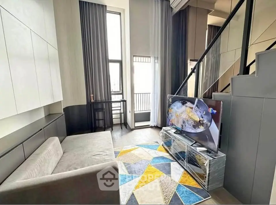 Modern living room with high ceiling and stylish decor in a contemporary apartment.