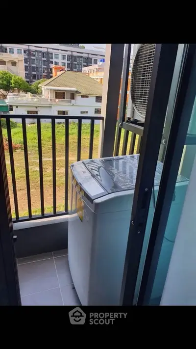 Compact balcony with washing machine and scenic view of neighborhood