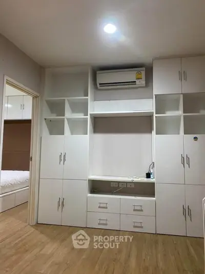 Modern bedroom with built-in white cabinetry and air conditioning unit