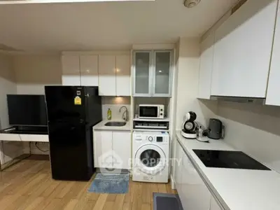 Modern kitchen with sleek appliances and washing machine in compact layout