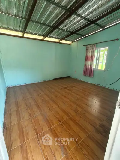 Spacious empty room with tiled flooring and natural light, ideal for customization.