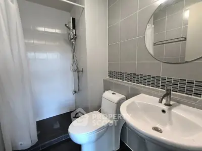 Modern bathroom with sleek fixtures and tiled walls in a contemporary apartment.