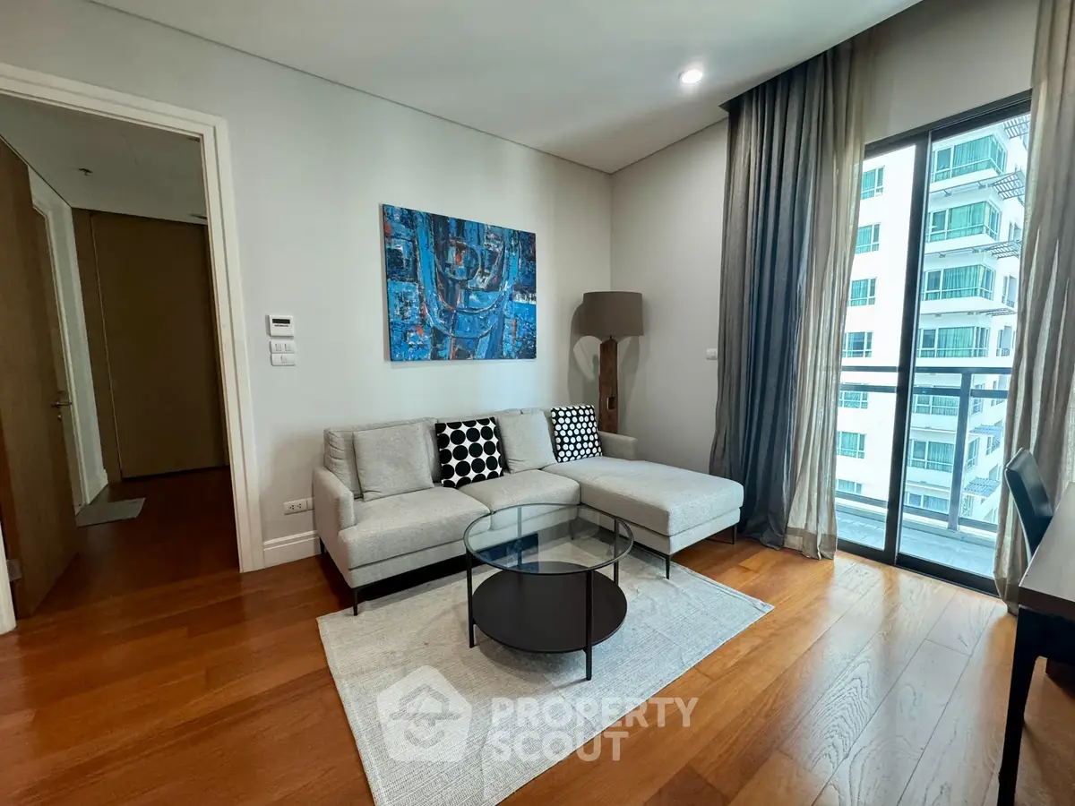 Modern living room with stylish decor and large window in a high-rise apartment.