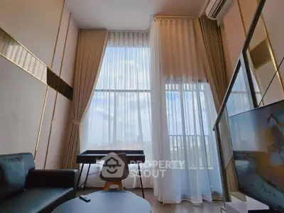 Modern living room with high ceilings, large windows, and stylish furniture offering a bright and airy ambiance.