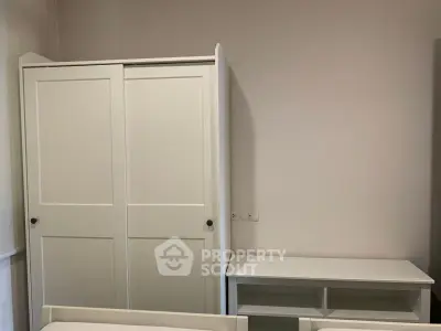 Minimalist bedroom with white wardrobe and desk, perfect for modern living.