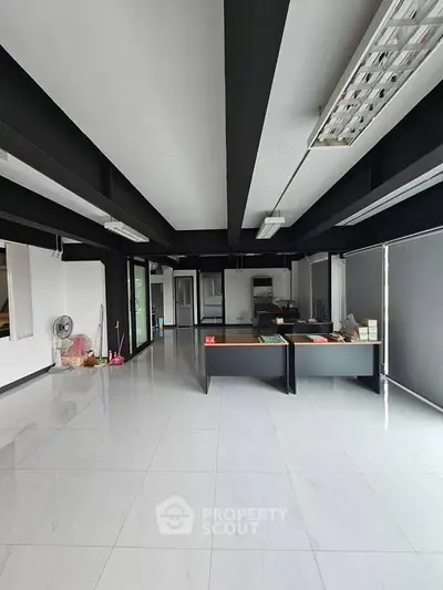 Spacious modern office space with sleek black beams and large windows