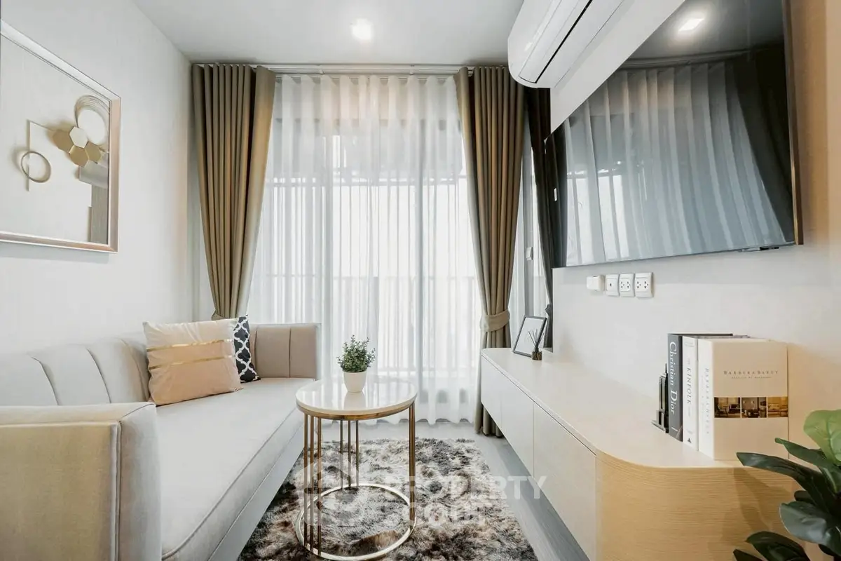 Modern living room with stylish decor and large window, featuring a cozy sofa and elegant furnishings.