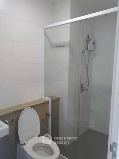 Modern bathroom with glass shower and sleek white tiles