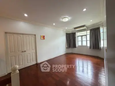 Spacious living room with wooden flooring and ample natural light