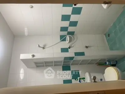 Modern bathroom with blue and white tiles, featuring a shower and toilet.