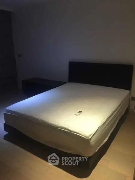 Spacious bedroom with minimalist decor and a comfortable bed, ideal for relaxation.