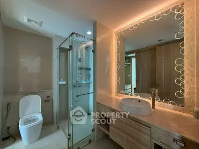 Modern bathroom with glass shower and elegant vanity in luxury apartment.
