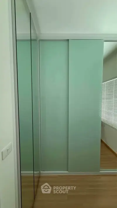 Modern bedroom with sleek sliding closet doors and wooden flooring