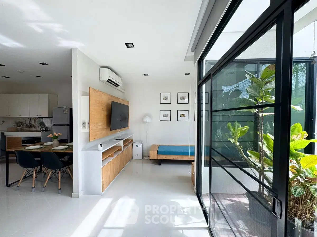 Modern open-layout living space with kitchen and balcony view