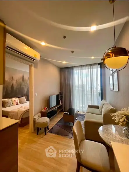 Modern open-plan living room with cozy seating and natural light in a stylish apartment.