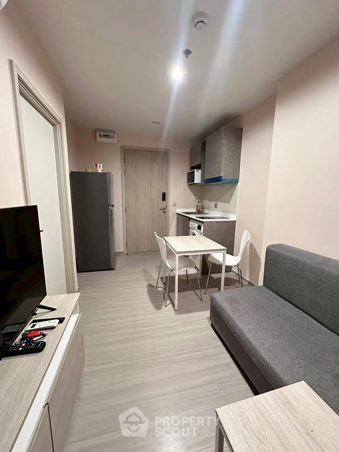 Modern compact living room with kitchenette and dining area in stylish apartment