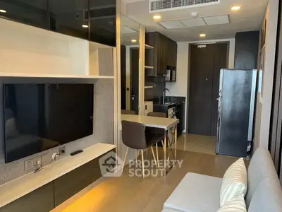 Modern apartment interior with open kitchen and cozy living area, featuring sleek design and contemporary furnishings.