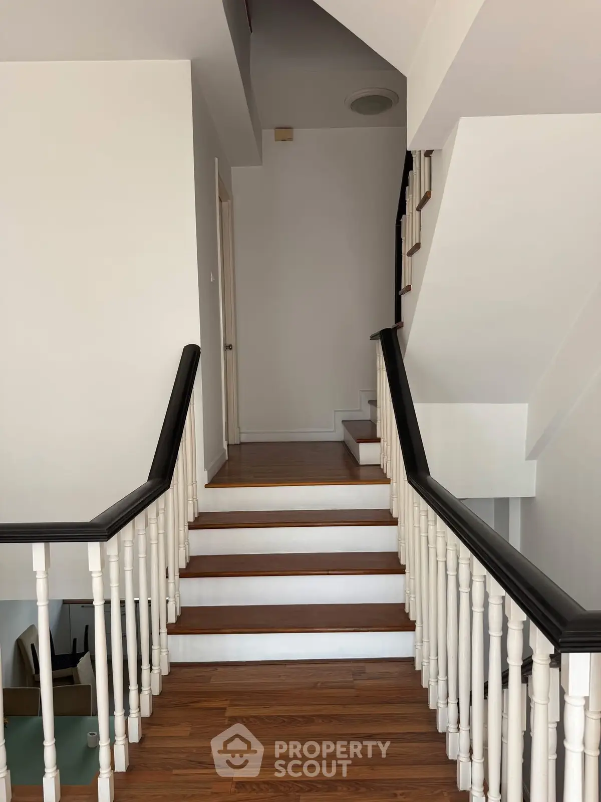 Elegant staircase with wooden steps and white railings in modern home
