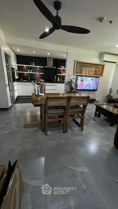 Modern open-layout living room with sleek kitchen and stylish dining area, perfect for contemporary living.