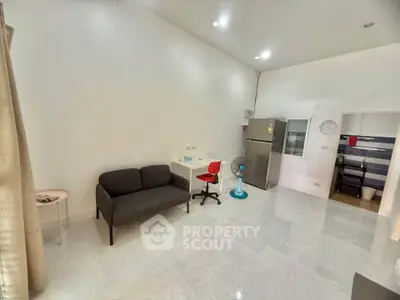 Spacious modern living area with sleek furniture and stainless steel appliances