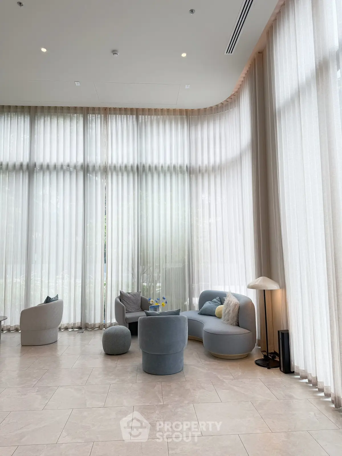Luxurious modern living room with floor-to-ceiling windows and elegant furniture, perfect for relaxation.