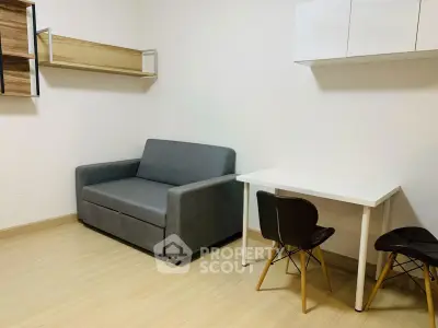 Cozy minimalist living room with modern gray sofa and sleek white table, perfect for urban living.