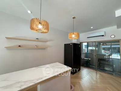 Modern kitchen with elegant lighting and sleek appliances in a stylish open layout.