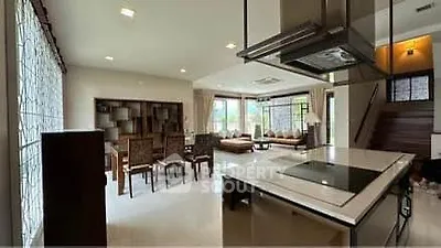 Spacious open-plan living and dining area with modern kitchen and large windows