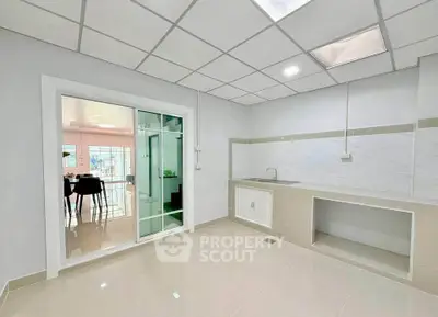 Modern kitchen with sleek design and open layout, featuring sliding glass doors and ample natural light.