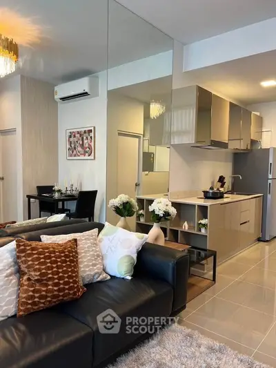 Modern open-layout living room and kitchen with sleek design and cozy decor.