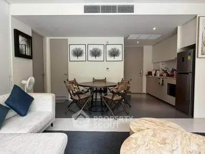 Modern open-plan living room with dining area and kitchen, featuring stylish decor and comfortable seating.