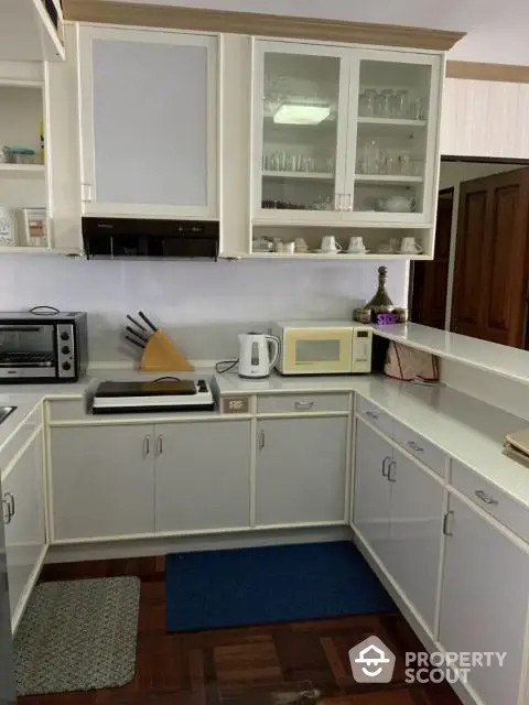 Charming kitchen with white cabinets and modern appliances, perfect for culinary enthusiasts.