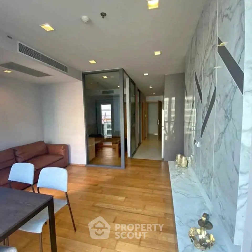 Modern living room with marble accents and wooden flooring in a stylish apartment.