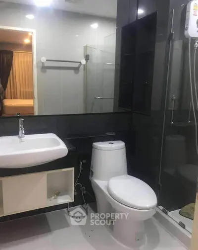 Modern bathroom with sleek fixtures and glass shower in contemporary apartment.