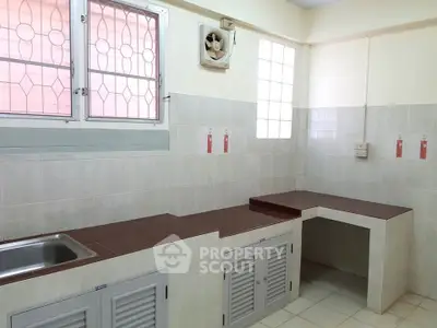 Spacious kitchen with tiled countertops and ample natural light